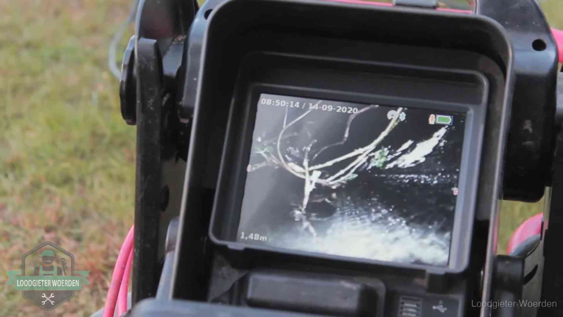 Camera-inspectie van het riool in Woerden Monitor van een rioolcamera toont wortelingroei in de rioolbuis bij een woning in Woerden