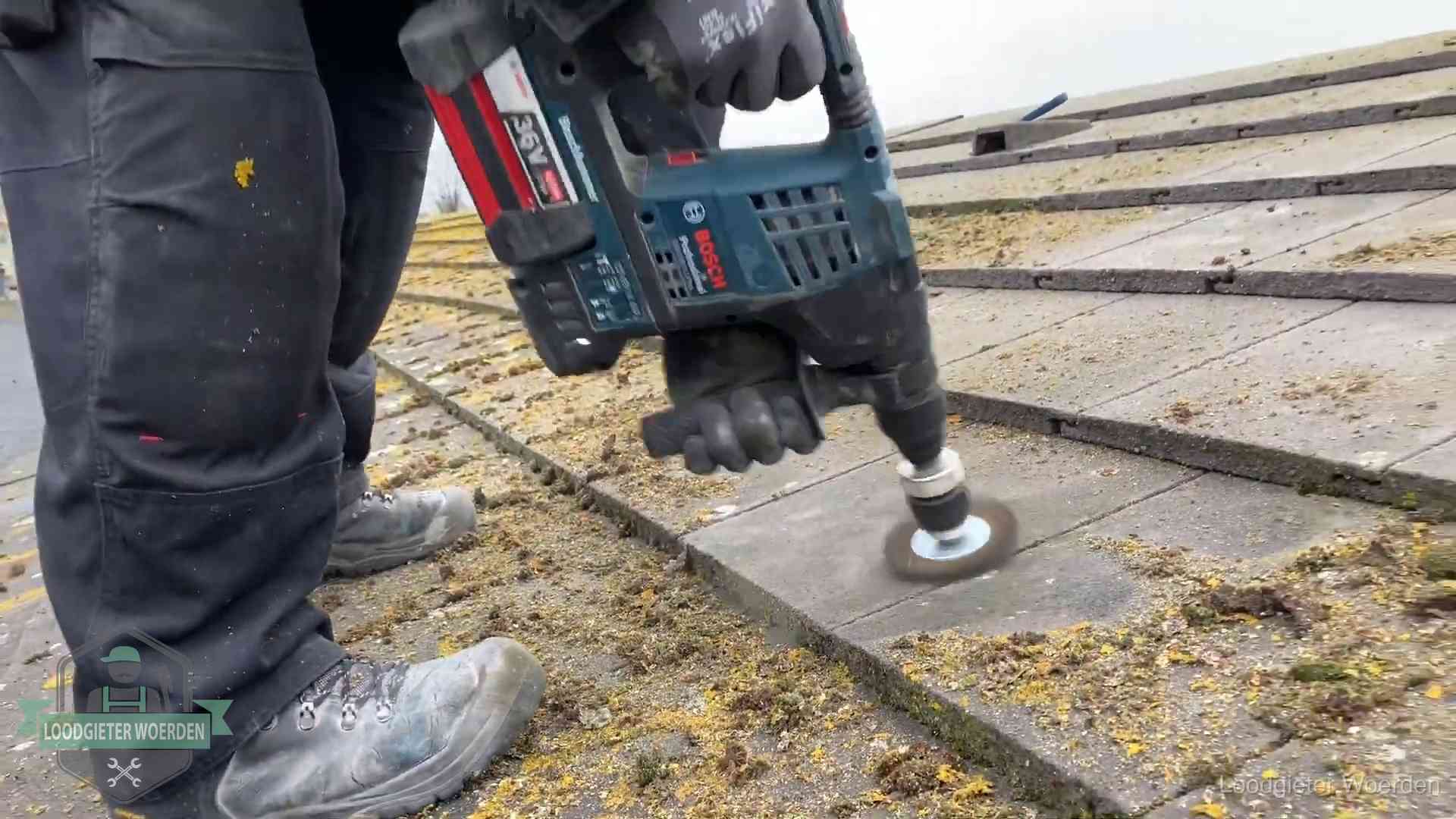 Betonnen dakpannen worden machinaal gereinigd tijdens dakonderhoud in Woerden