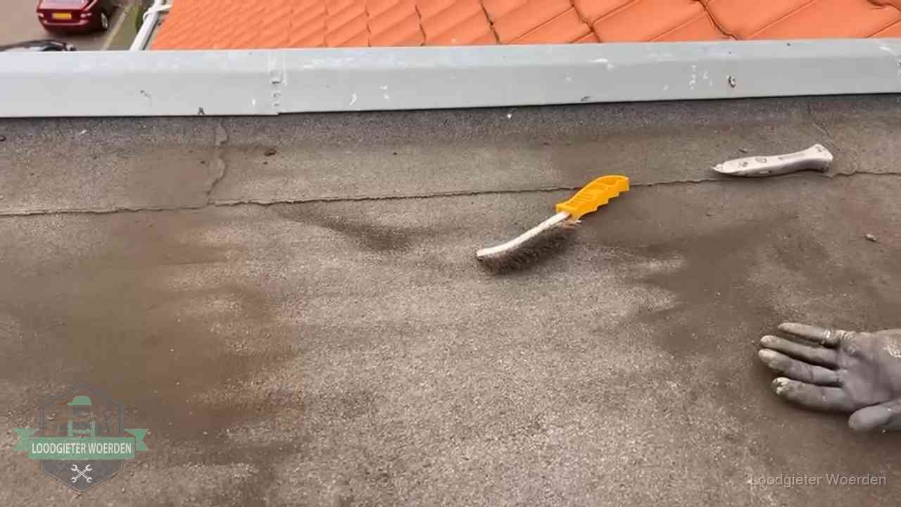 Dakdekker bereidt een bitumen plat dak voor op reparatie bij de daktrim in Woerden
