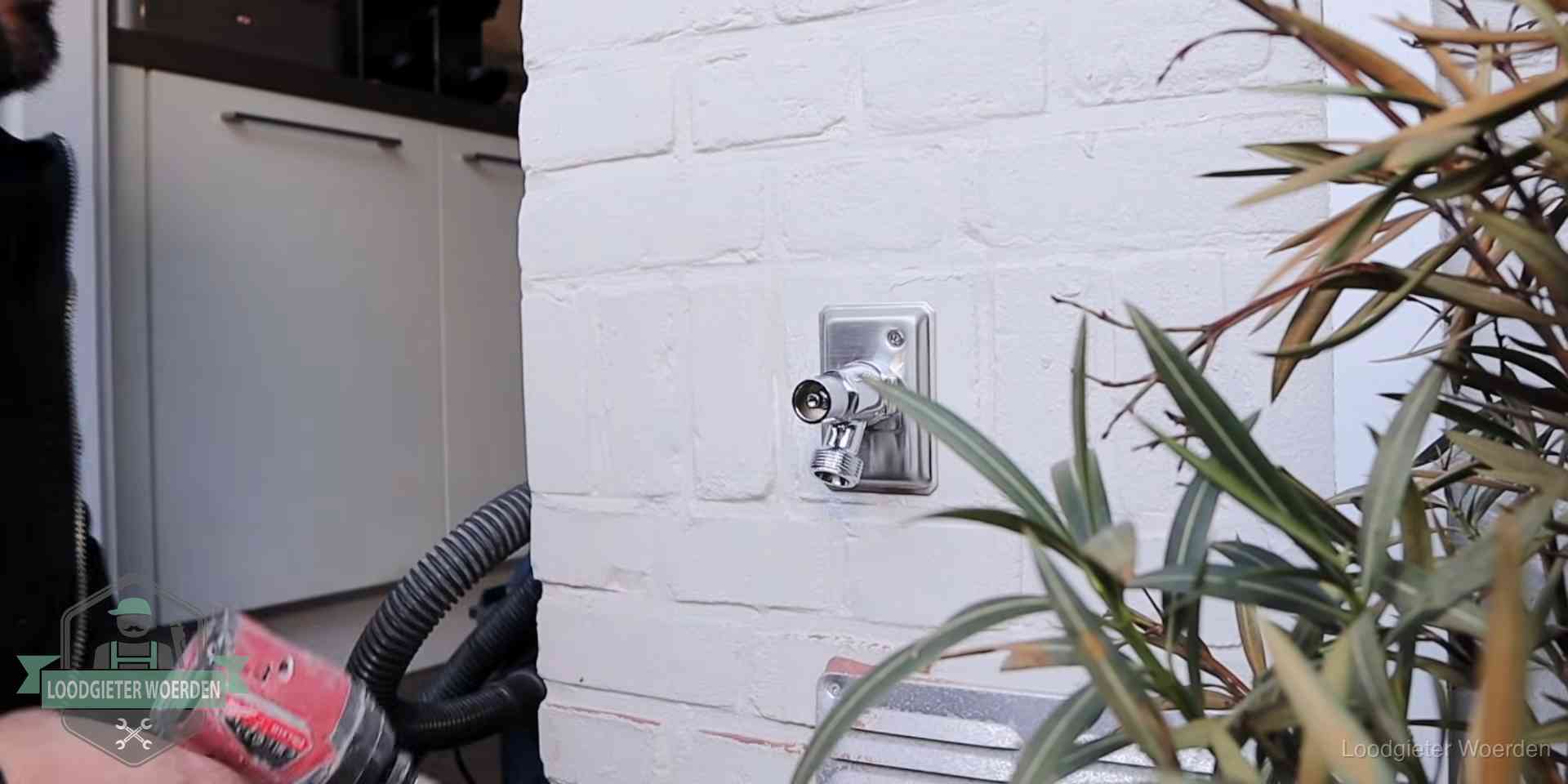 Chromen kraan op een muurplaat bij een woning in Woerden, dichtdraaien is stap een van de lektest