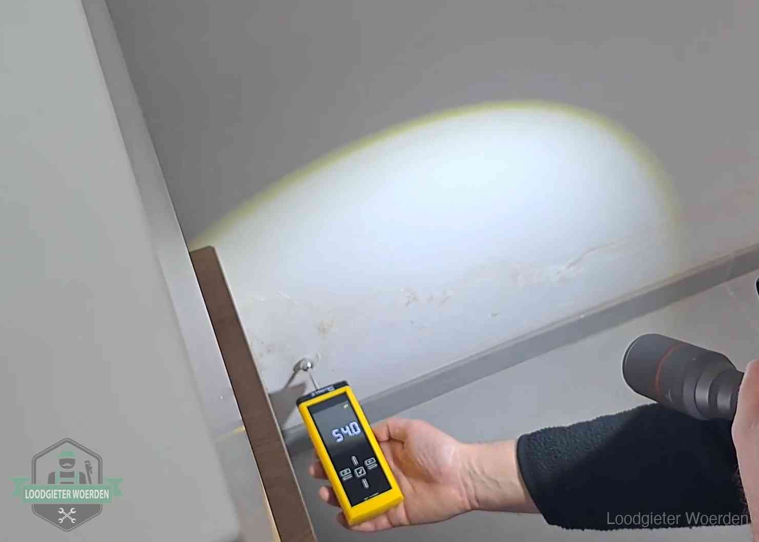 Vochtmeter tegen een natte wand met lekkagesporen in Woerden