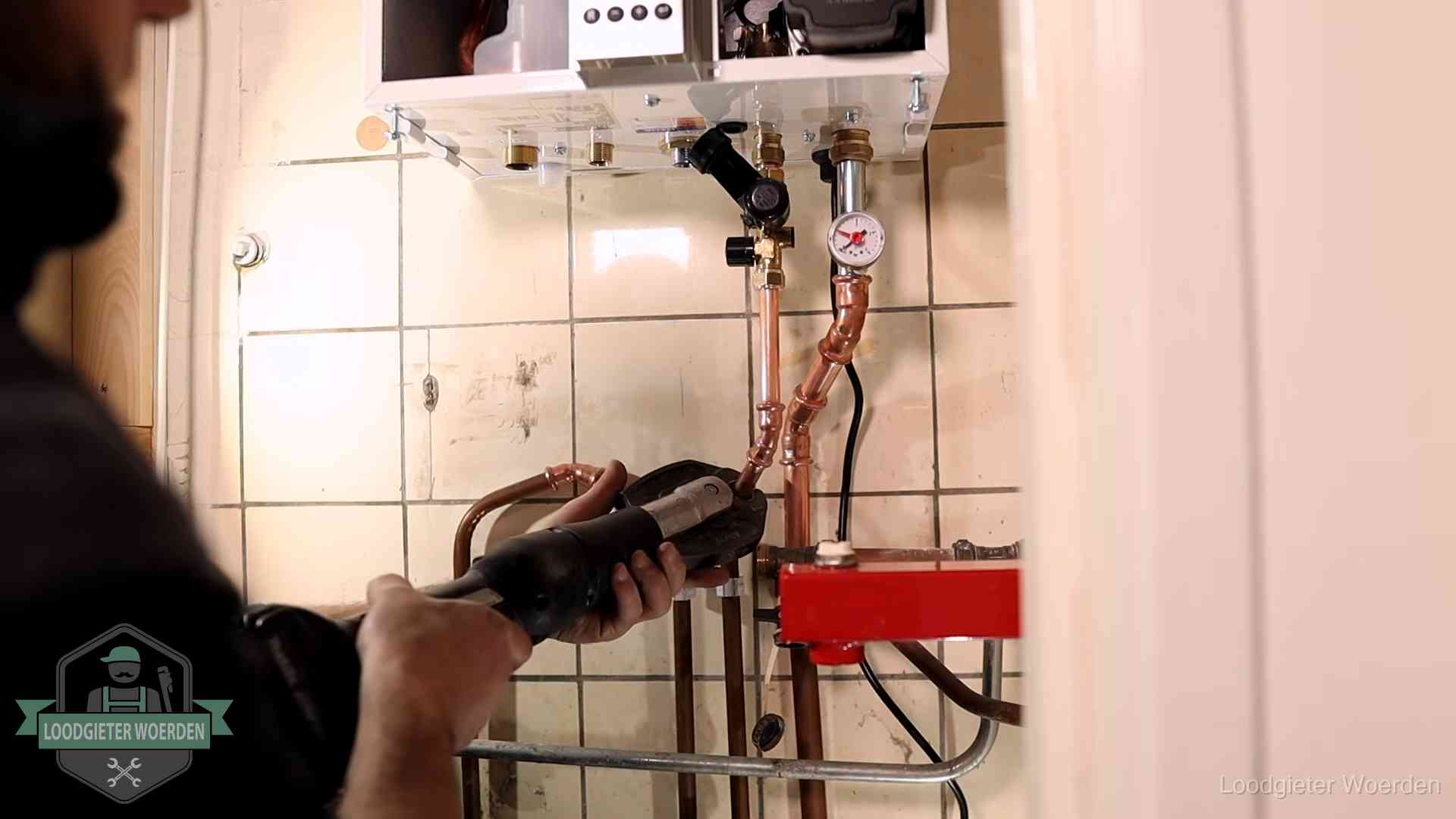 Cv-ketel onderhoud in Woerden Monteur werkt aan de leidingen onder een cv-ketel in Woerden