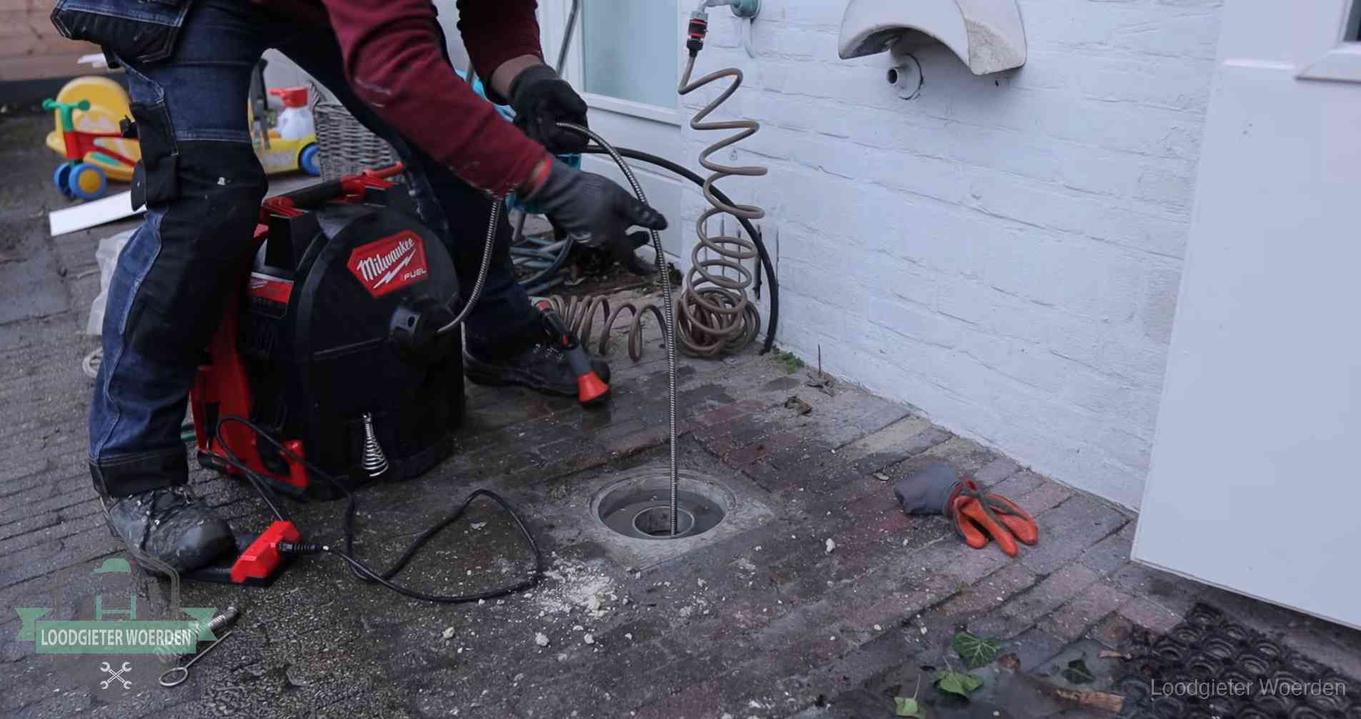 Erfgrens en gemeenteriool in Woerden Ontstoppingsputje in de bestrating naast de gevel van een woning in Woerden