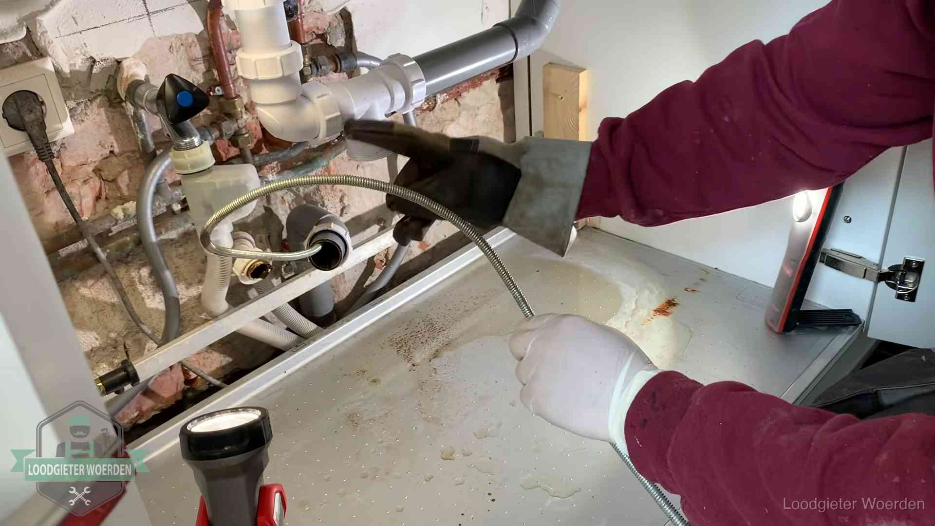 Spiraal of hogedruk in Woerden Ontstoppingsveer gaat in een geopende sifonaansluiting onder het aanrecht in Woerden