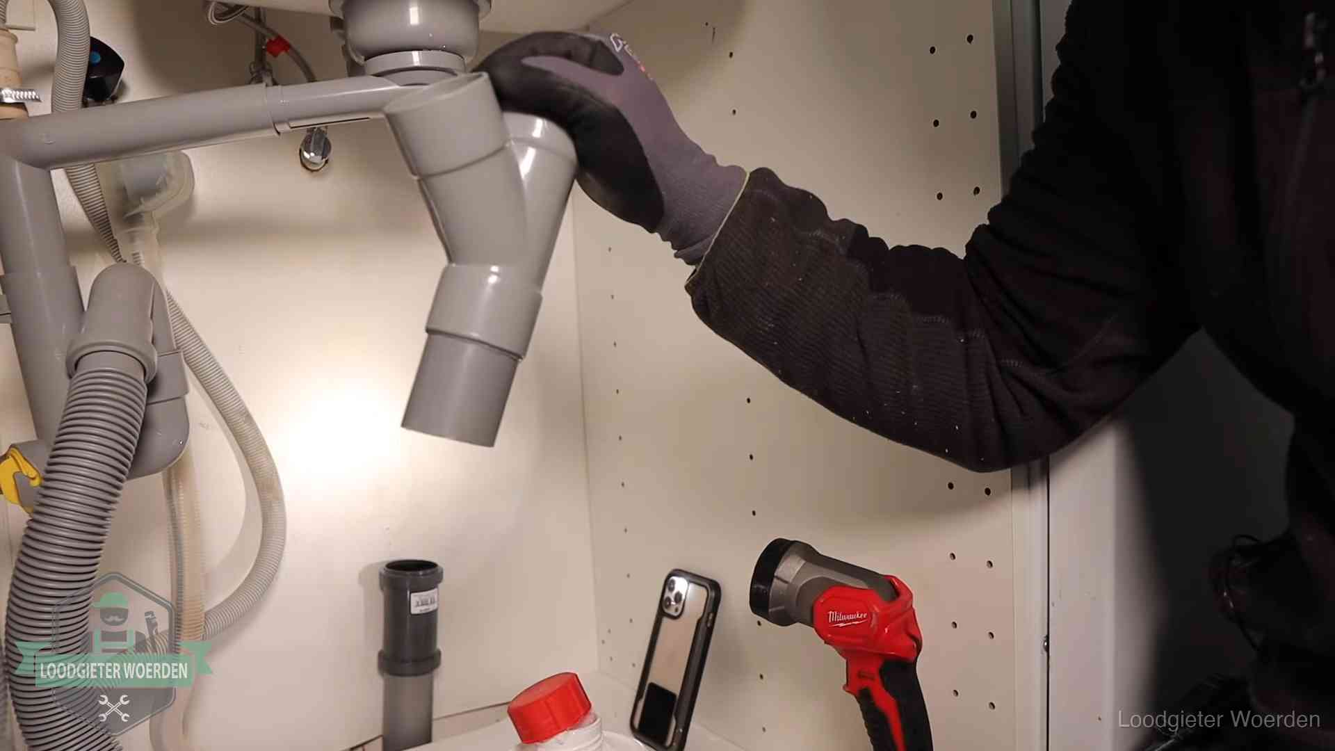 Rioollucht in huis verhelpen in Woerden Loodgieter demonteert het sifon- en afvoerwerk onder een gootsteen in Woerden bij stankklachten