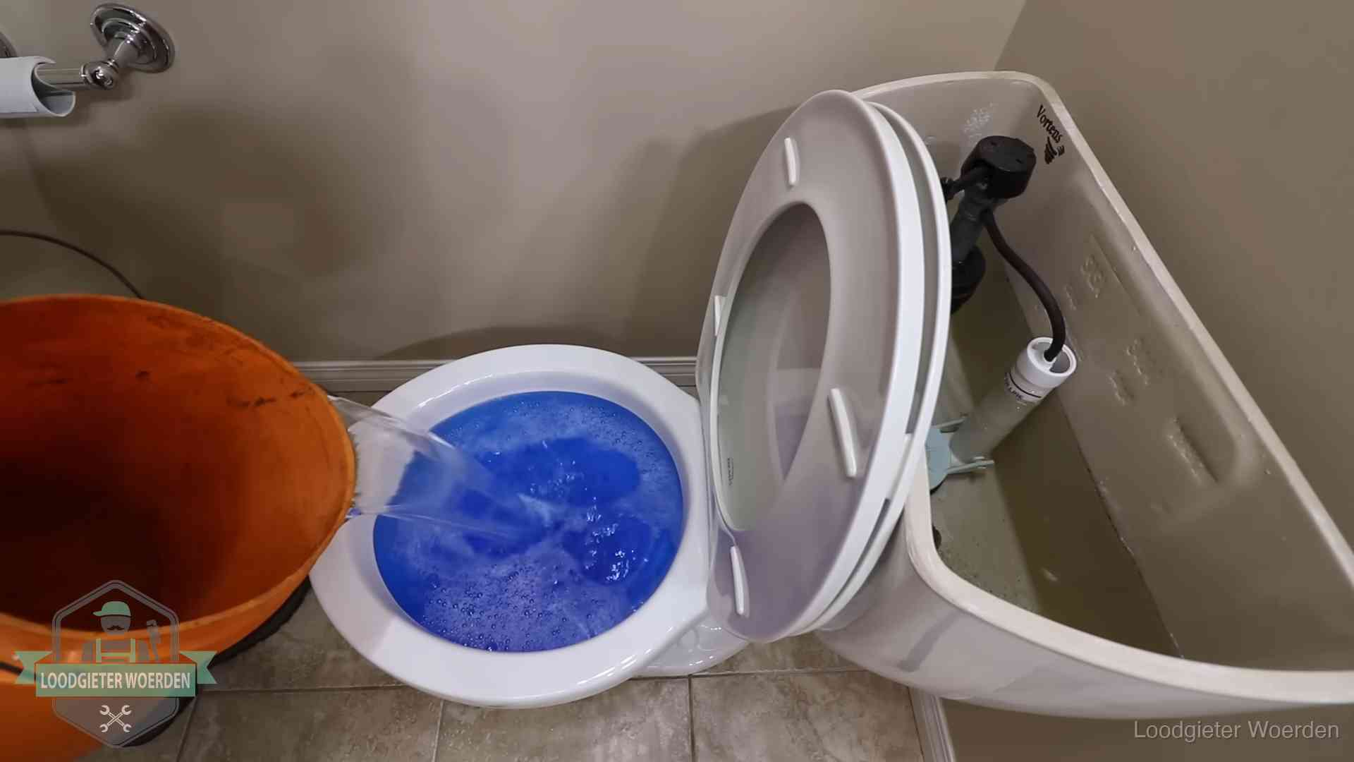 Water komt omhoog in de wc in Woerden Water bij de wc-pot wordt met een emmer weggewerkt om schade te beperken in Woerden